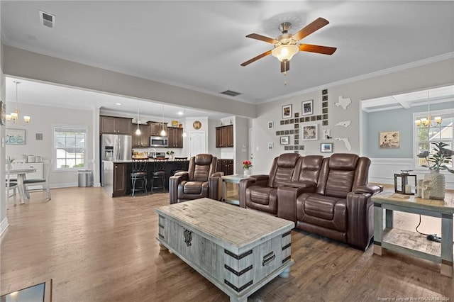 living room featuring ceiling fan with notable chandelier, dark hardwood / wood-style floors, and ornamental molding