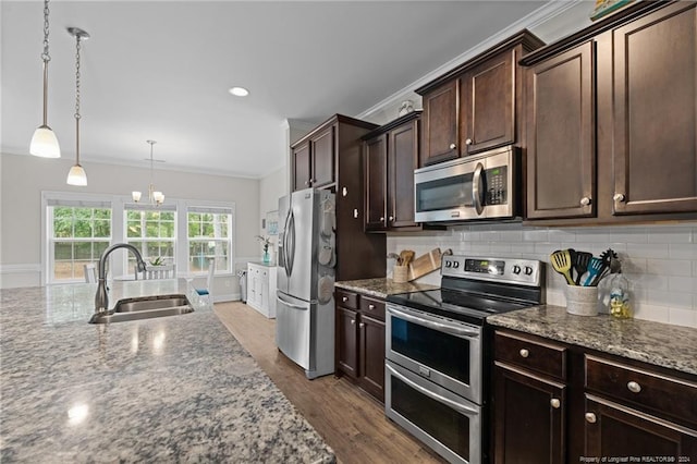 kitchen featuring sink, stainless steel appliances, dark hardwood / wood-style flooring, crown molding, and decorative light fixtures