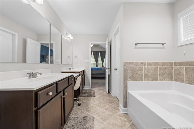 bathroom featuring a washtub, vanity, and tile patterned flooring