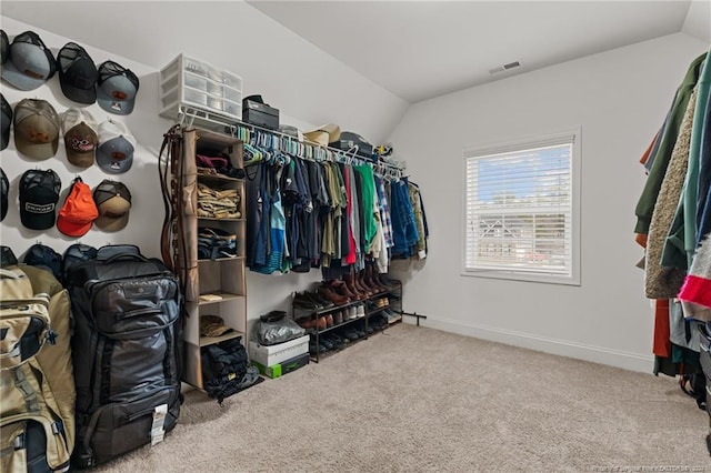 walk in closet with carpet and lofted ceiling