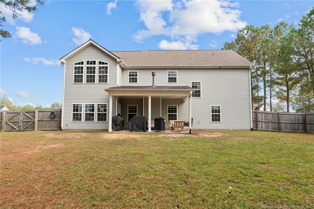 rear view of property featuring a patio area and a lawn