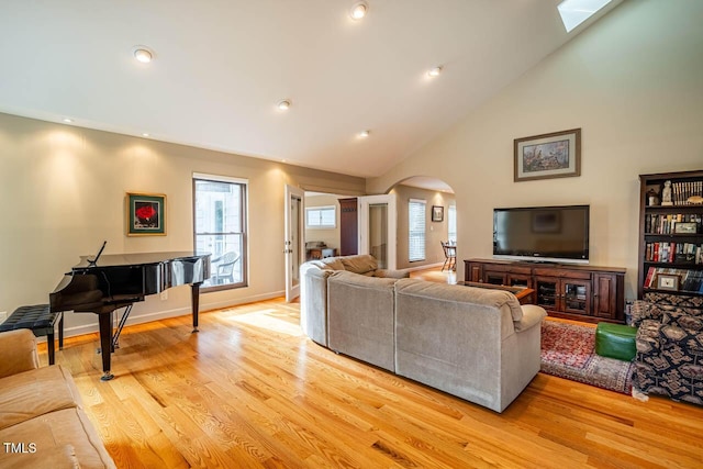 living room with light hardwood / wood-style floors and high vaulted ceiling