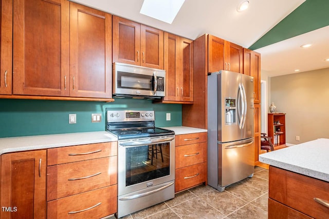 kitchen featuring stainless steel appliances and vaulted ceiling with skylight