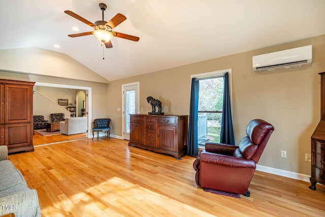 living room featuring light wood-type flooring, a wall unit AC, ceiling fan, and vaulted ceiling