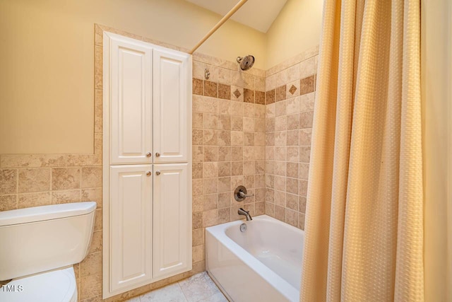 bathroom with tile patterned floors, toilet, tile walls, and shower / tub combo with curtain