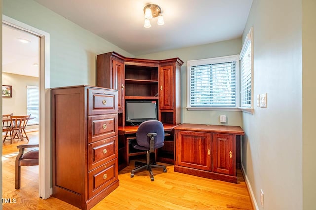 home office with light hardwood / wood-style floors