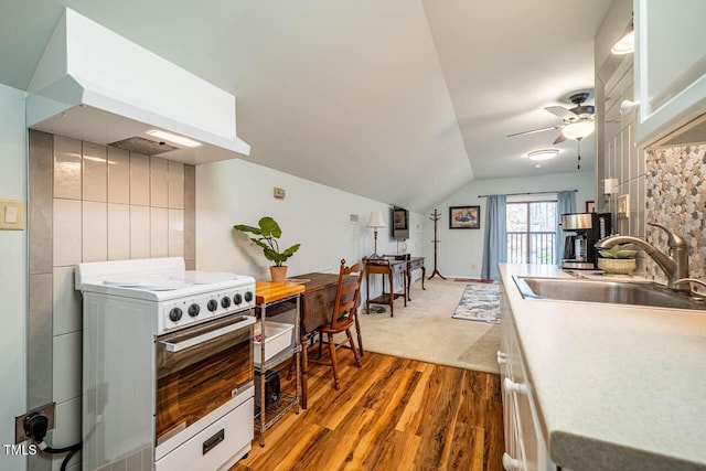 kitchen with extractor fan, vaulted ceiling, sink, electric range, and light wood-type flooring