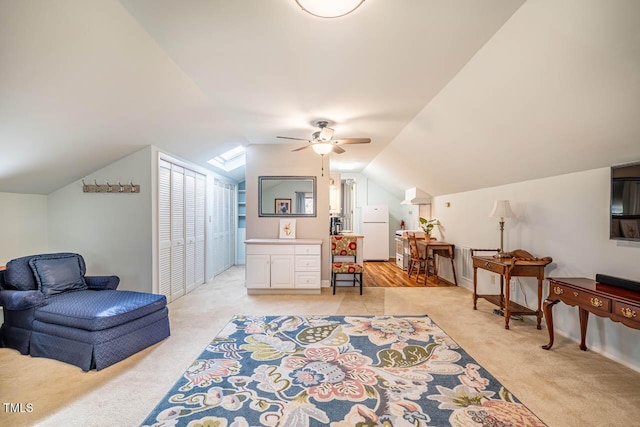 living area with ceiling fan, light colored carpet, and lofted ceiling