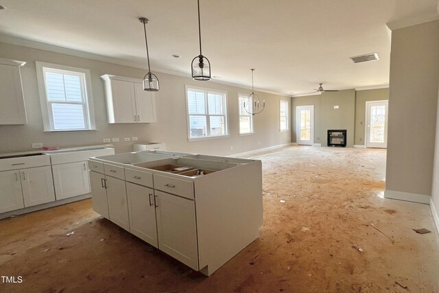 kitchen with pendant lighting, crown molding, plenty of natural light, and white cabinets