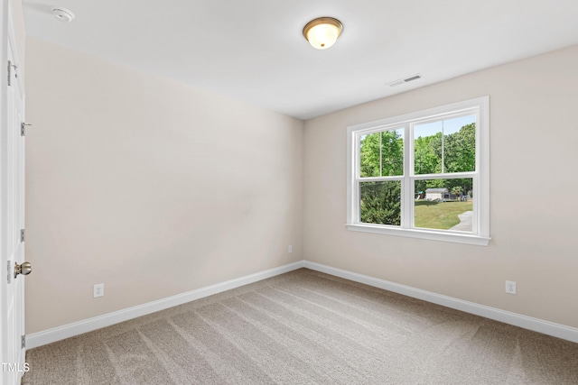 empty room featuring carpet floors, baseboards, and visible vents