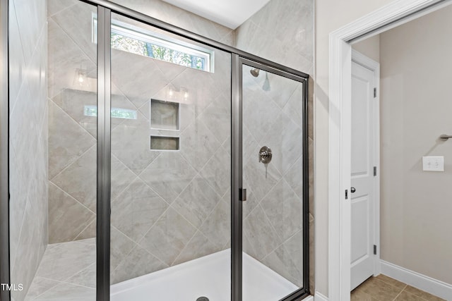 full bath with baseboards, a shower stall, and tile patterned floors