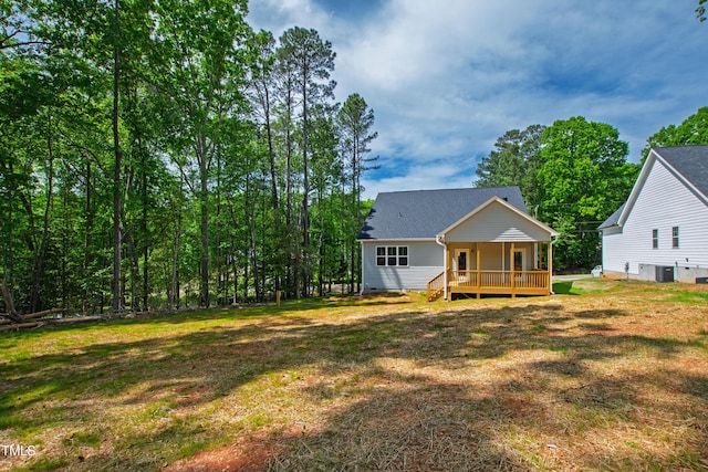 rear view of house featuring covered porch, a yard, crawl space, and cooling unit