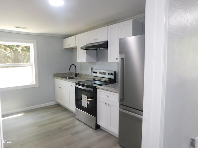 kitchen with white cabinetry, sink, light stone countertops, appliances with stainless steel finishes, and light wood-type flooring