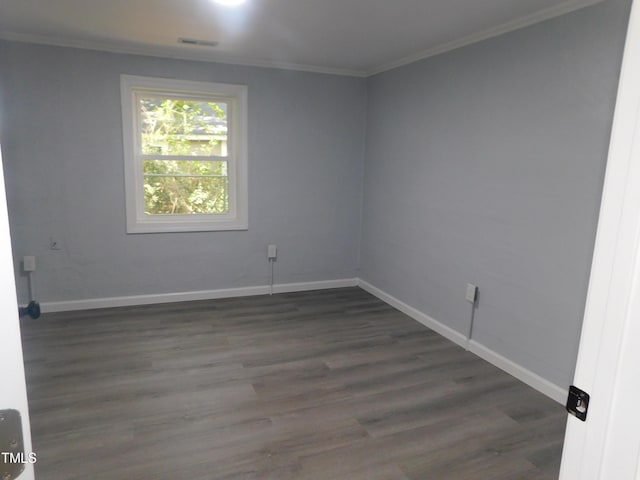 empty room featuring crown molding and dark hardwood / wood-style flooring