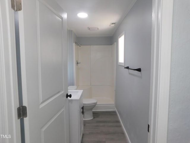 bathroom with hardwood / wood-style floors, vanity, toilet, and walk in shower