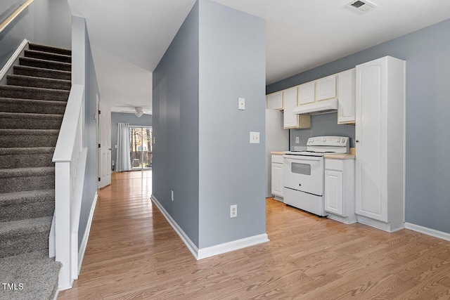 kitchen featuring white range with electric cooktop, white cabinets, and light hardwood / wood-style flooring