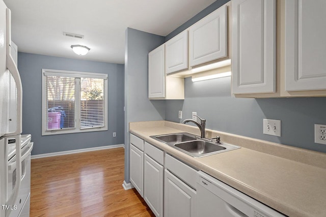 kitchen with white dishwasher, white cabinetry, sink, and light hardwood / wood-style flooring