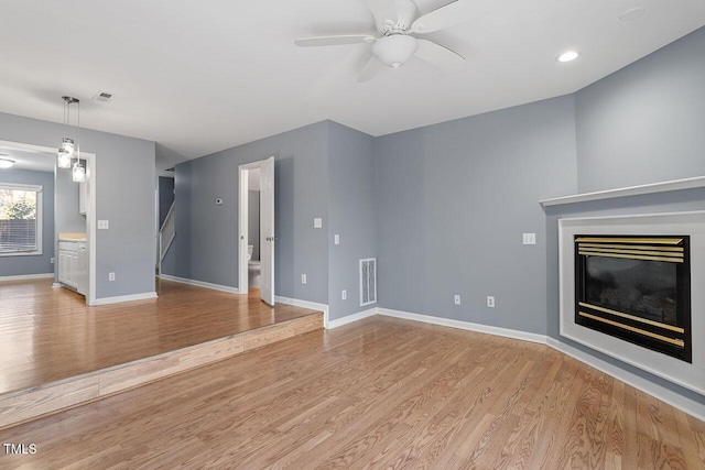 unfurnished living room featuring light hardwood / wood-style floors and ceiling fan