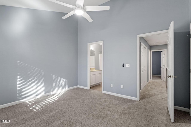 unfurnished bedroom featuring light carpet, ensuite bath, and ceiling fan