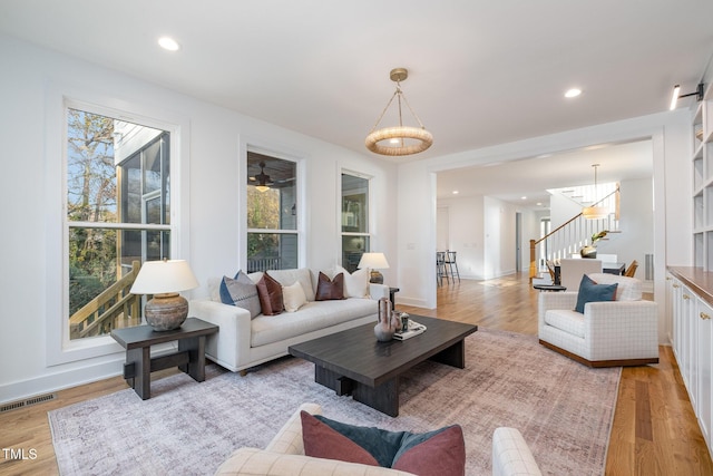 living room with light hardwood / wood-style floors, a wealth of natural light, and ceiling fan