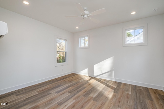 empty room featuring ceiling fan, wood-type flooring, and a wealth of natural light