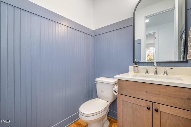 bathroom featuring vanity, wood-type flooring, and toilet