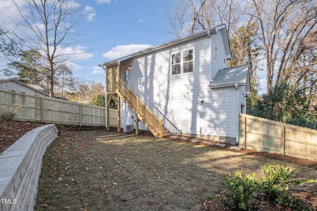 back of property featuring central AC and a yard