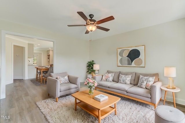 living room featuring light hardwood / wood-style floors and ceiling fan