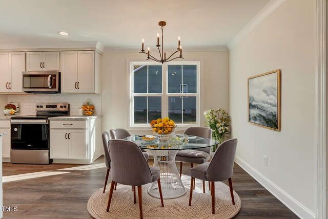 dining space with ornamental molding, dark wood-type flooring, and an inviting chandelier