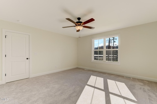 carpeted spare room featuring ceiling fan