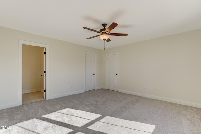 unfurnished room with ceiling fan and light carpet