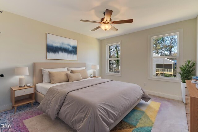 carpeted bedroom with multiple windows and ceiling fan