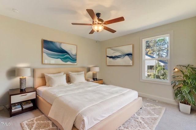 bedroom with ceiling fan and light carpet