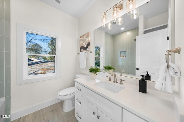 bathroom with hardwood / wood-style flooring, vanity, a healthy amount of sunlight, and toilet