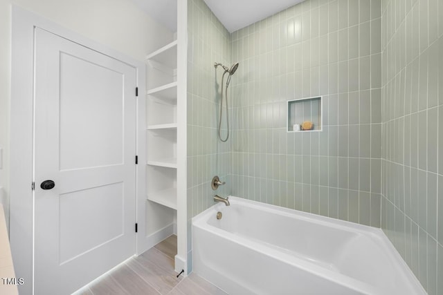 bathroom featuring hardwood / wood-style flooring and tiled shower / bath