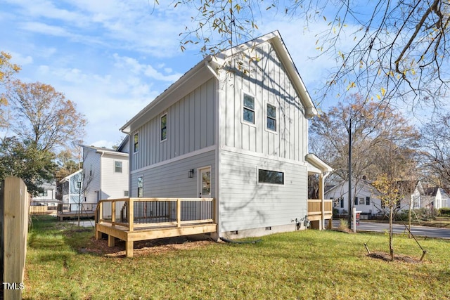 rear view of property featuring a lawn and a deck