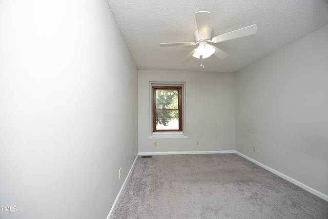 carpeted spare room featuring ceiling fan and a textured ceiling