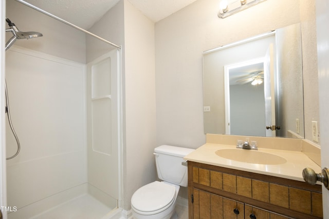 bathroom featuring ceiling fan, toilet, a textured ceiling, and vanity