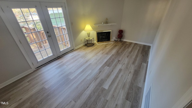 unfurnished living room featuring light wood-type flooring and french doors