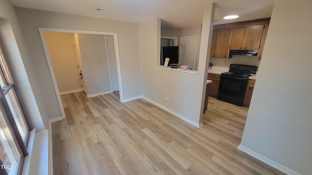 kitchen with black electric range and light hardwood / wood-style floors