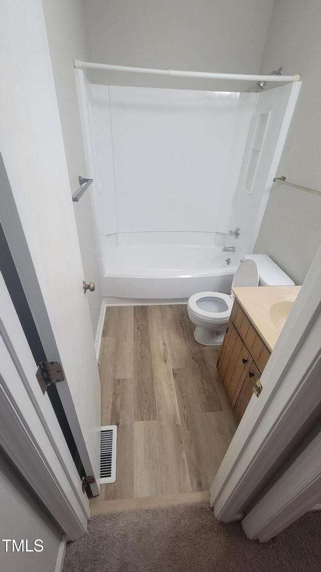 full bathroom with wood-type flooring, vanity, toilet, and  shower combination