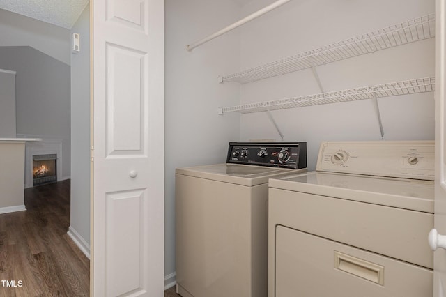 washroom featuring a textured ceiling, separate washer and dryer, and dark hardwood / wood-style floors