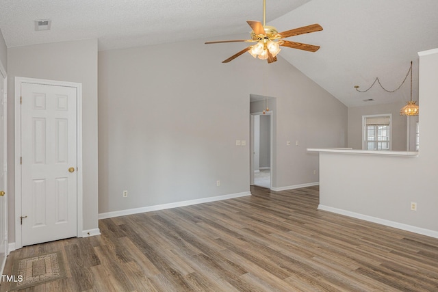 unfurnished living room with hardwood / wood-style floors, ceiling fan with notable chandelier, a textured ceiling, and lofted ceiling