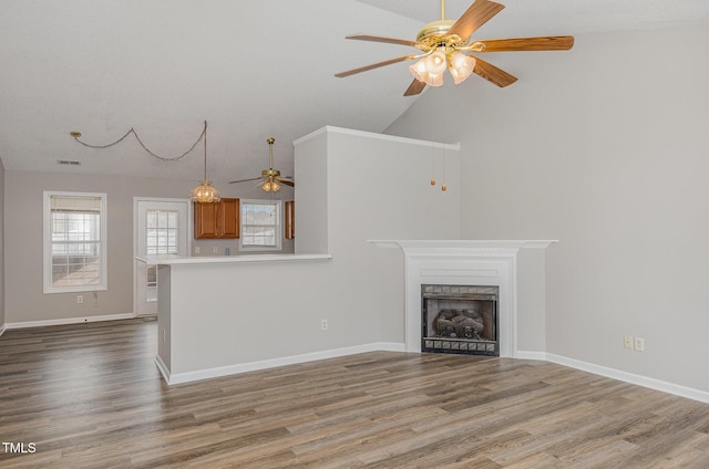 unfurnished living room with hardwood / wood-style floors, ceiling fan, and vaulted ceiling