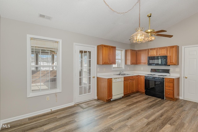 kitchen featuring a textured ceiling, white appliances, vaulted ceiling, ceiling fan, and light hardwood / wood-style floors