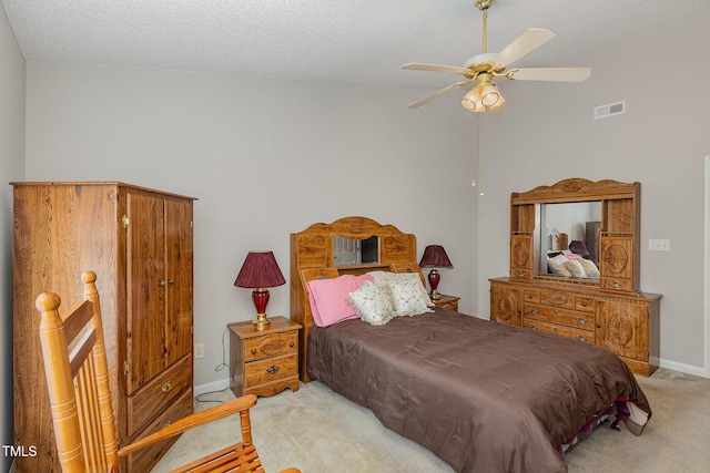 carpeted bedroom with a textured ceiling and ceiling fan