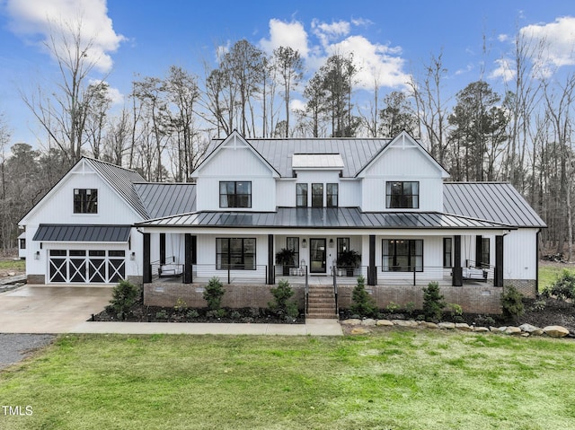 modern farmhouse style home with a garage, covered porch, and a front lawn