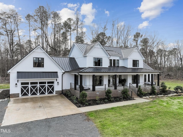 modern farmhouse style home with a front lawn, a porch, and a garage