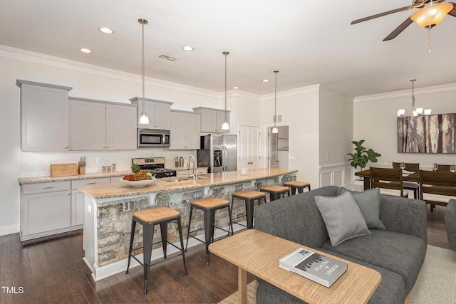 kitchen with gray cabinets, light stone counters, stainless steel appliances, and dark wood-type flooring