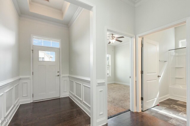 foyer entrance featuring plenty of natural light, dark wood-type flooring, and ornamental molding